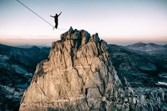 
		Man on a tightrope in the mountain
	